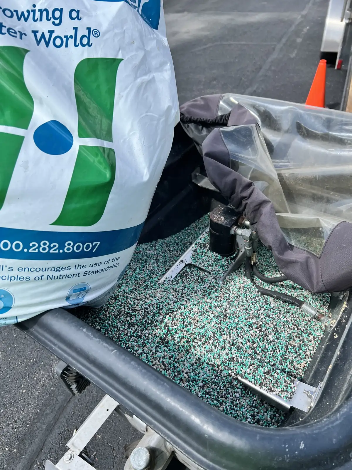 Close-up of professional-grade fertilizer granules being applied to lawn
